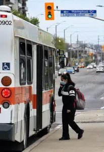 Woman in mask entering bus